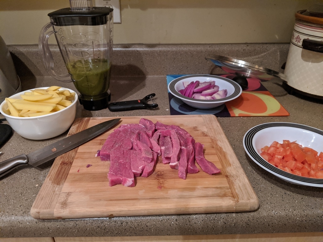 Prepared steak, onion, tomato, and potato.