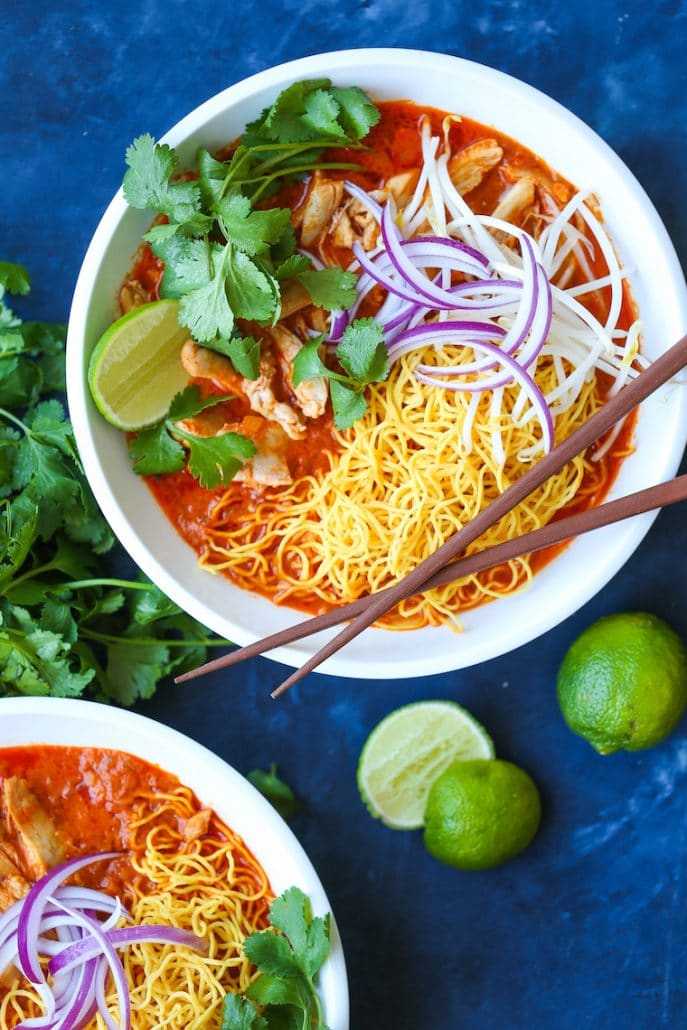 A bright red soupy curry sauce, with chicken, noodles, lime, bean sprouts, and cilantro