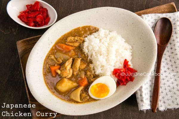 A light brown curry with chicken, carrots, potatoes, onion