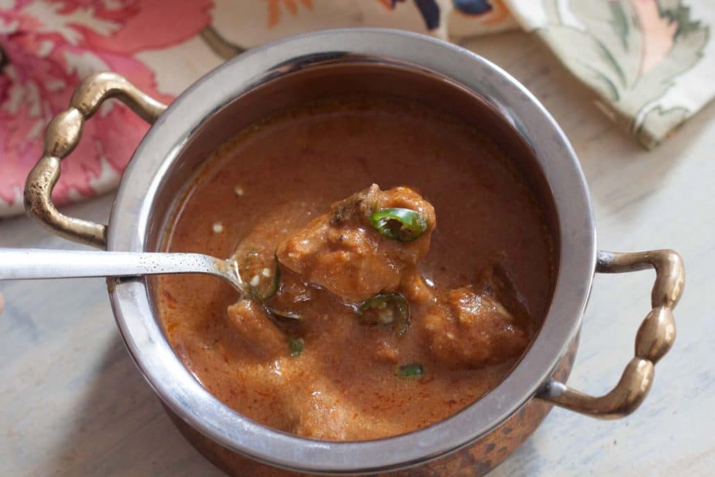 A soupy brown curry gravy with chicken chunks