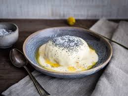 A germknodel with a creamy sauce and poppy seeds on top