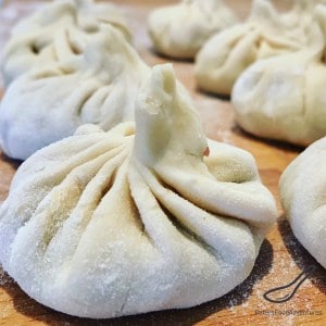 Round dumplings pinched at the top with ground beef inside, called khinkali