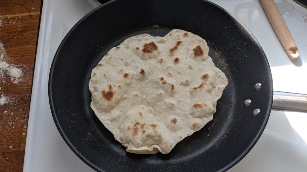A cooked tortilla in a skillet
